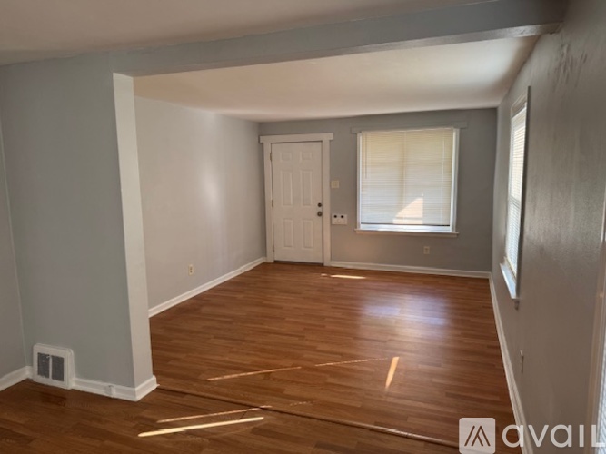 A room with wooden floors and a white door.