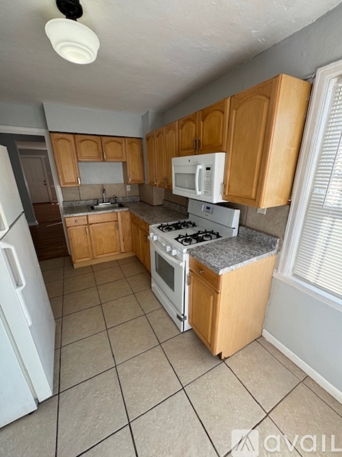 A kitchen with wooden cabinets and a white fridge.