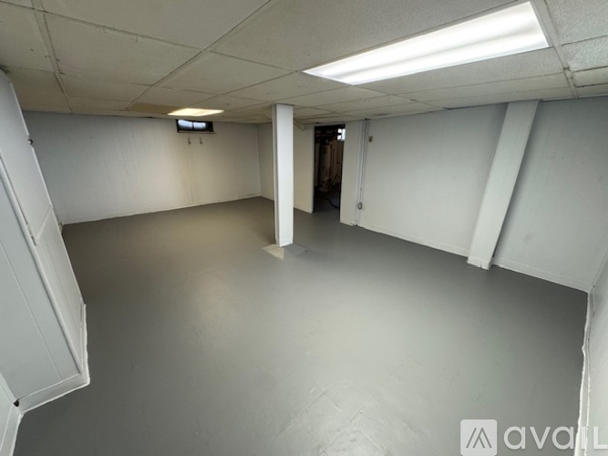 A spacious empty room with a white ceiling and walls.