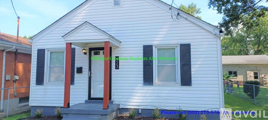 A small white house with a red door and black shutters.