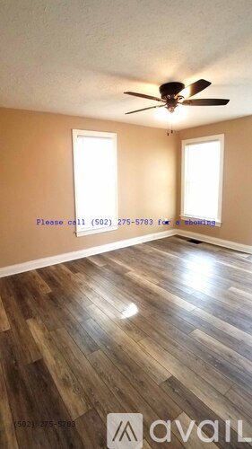 A room with a wood floor and a ceiling fan.