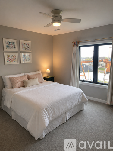A bedroom with a large bed and a window overlooking a construction site.