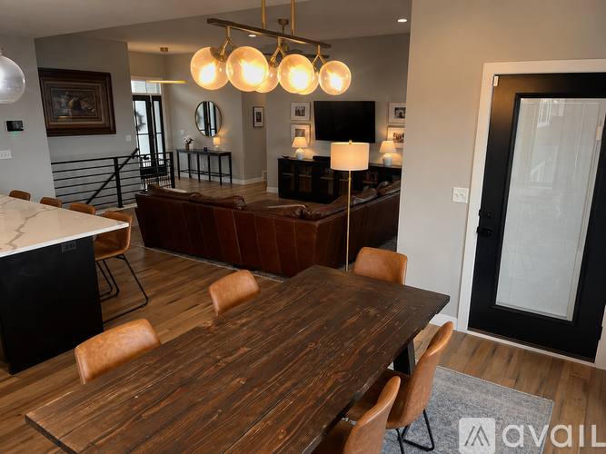 A modern dining room with a wooden table and chairs.