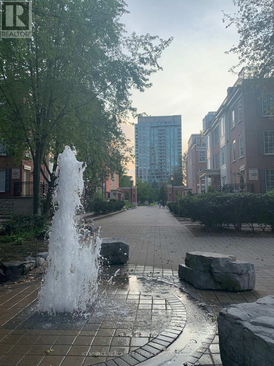 A fountain in the middle of a paved walkway.