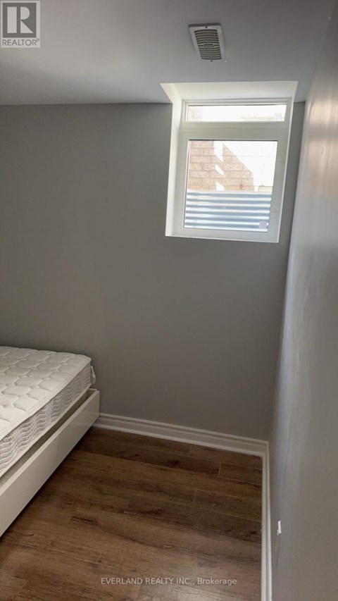 A bedroom with a bed and a window.
