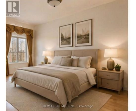 A bedroom with a large bed, two nightstands, and pictures on the wall.