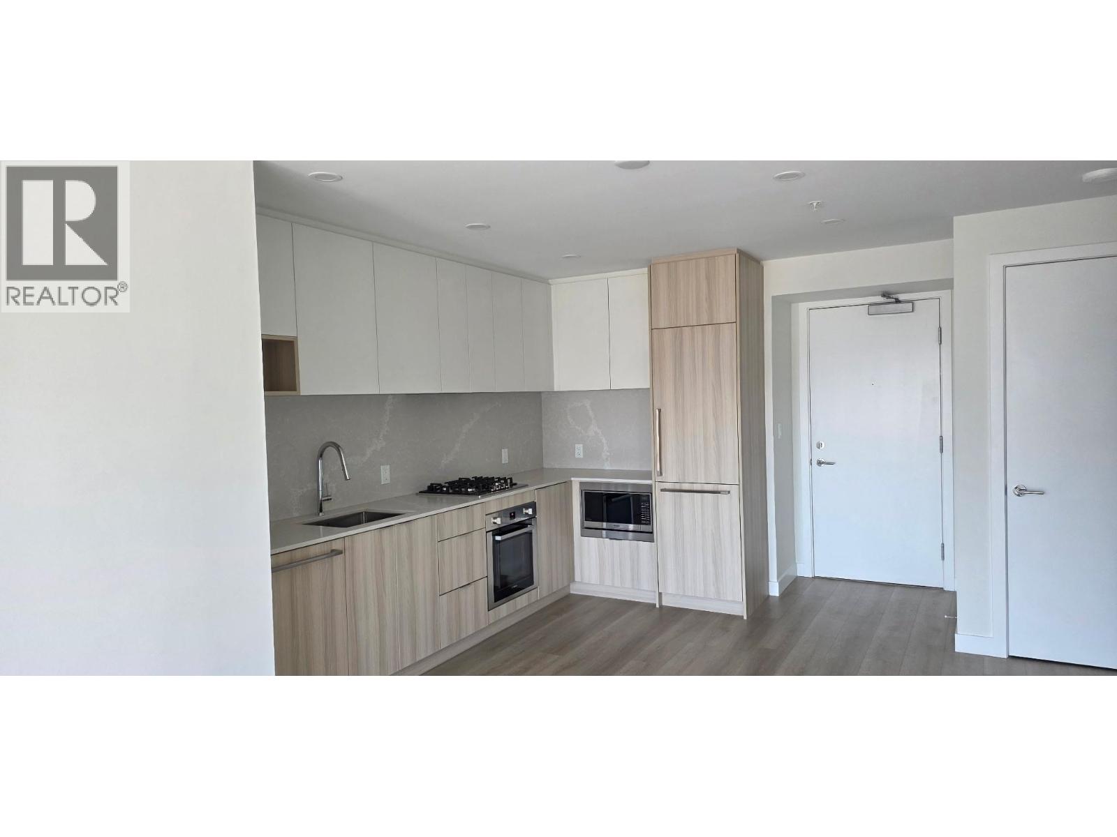 A kitchen with white cabinets and a wooden island.