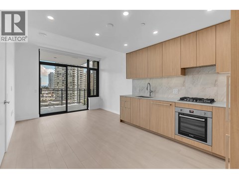A modern kitchen with wooden cabinets and a stainless steel oven.