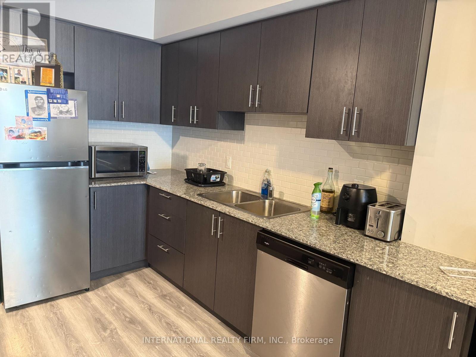 A kitchen with a stainless steel refrigerator, microwave, and dishwasher.
