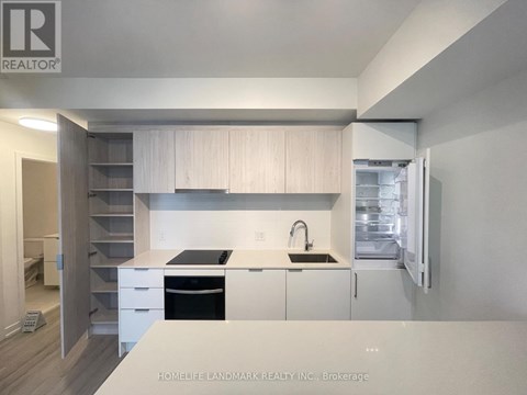 A modern kitchen with white cabinets and a black stove top oven.