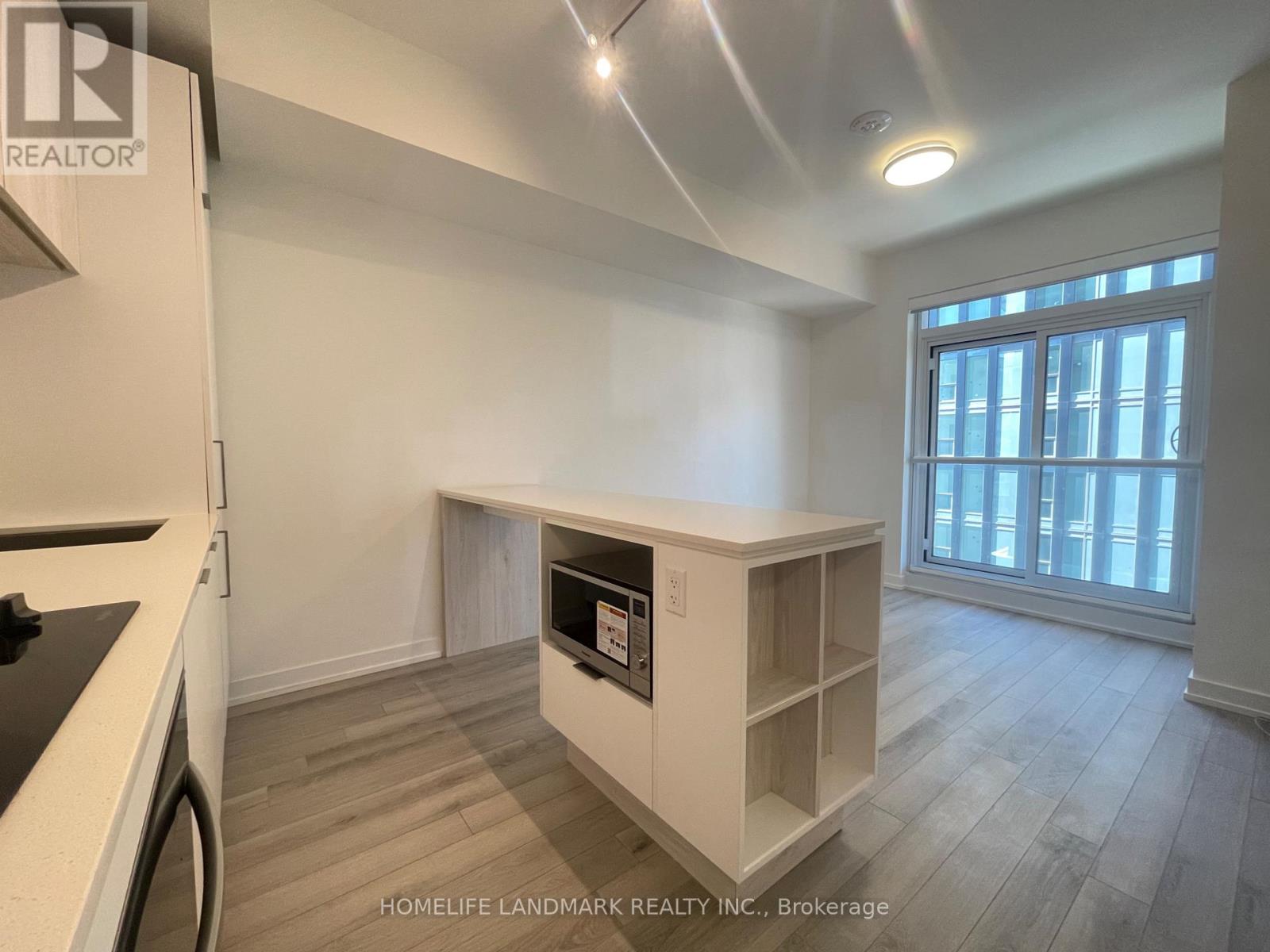A kitchen area with a stove top oven and a microwave built into a cabinet.