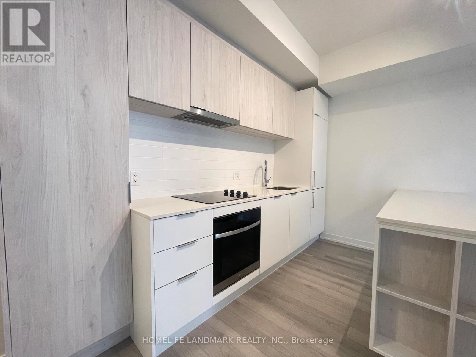 A kitchen with white cabinets and a wooden floor.