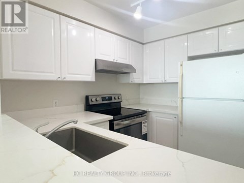 A kitchen with white cabinets and a stainless steel sink.