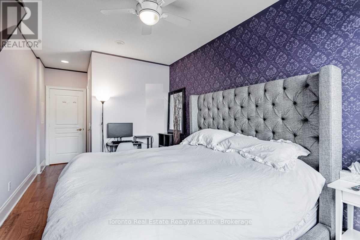 A bedroom with a large bed and a ceiling fan.