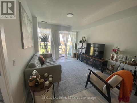 A living room with a grey couch and a television.