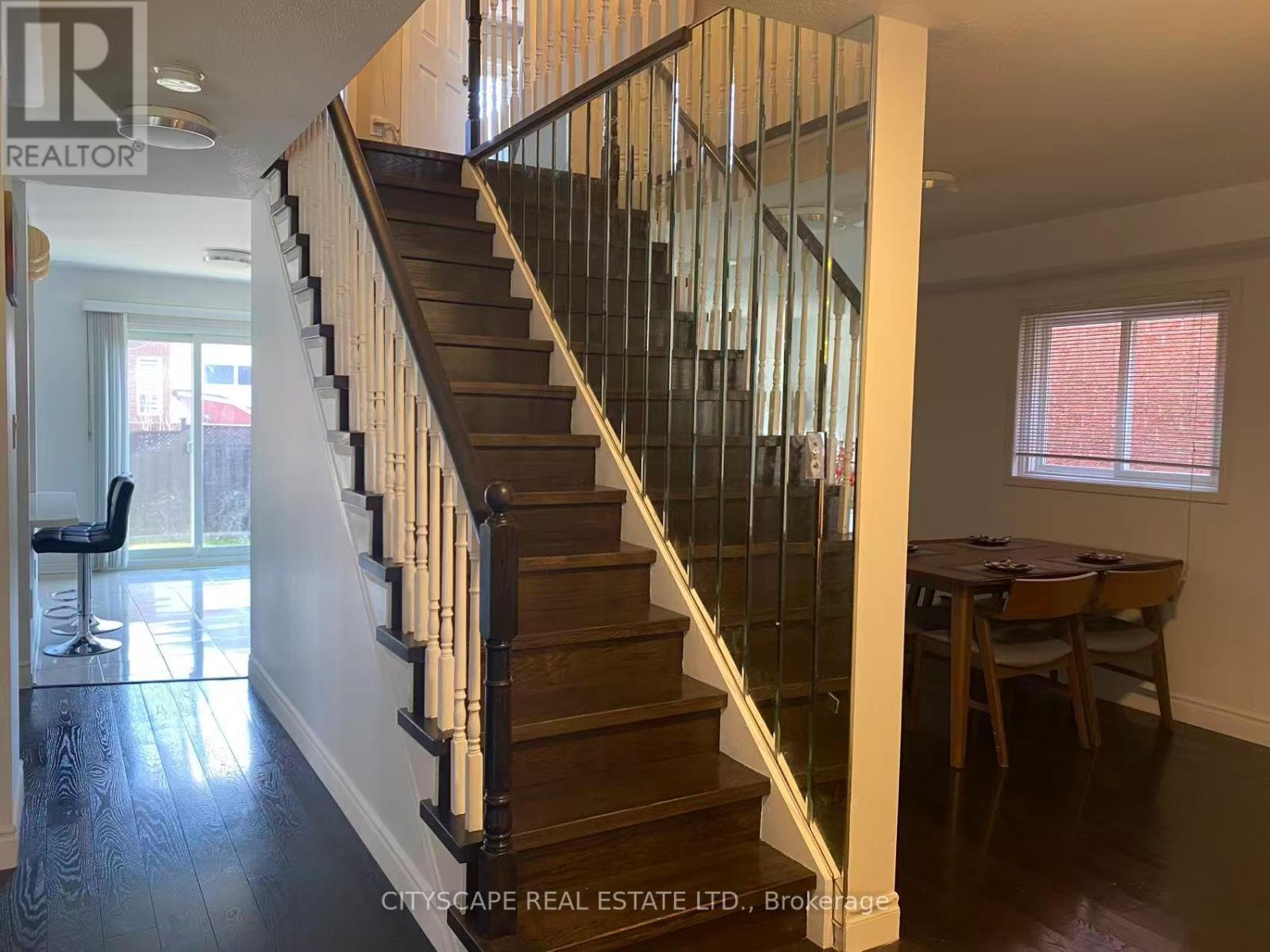 A staircase with a glass railing and wooden steps.