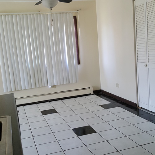 A room with a white ceiling fan and a window with blinds.