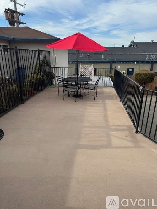 A red umbrella is on a patio table.