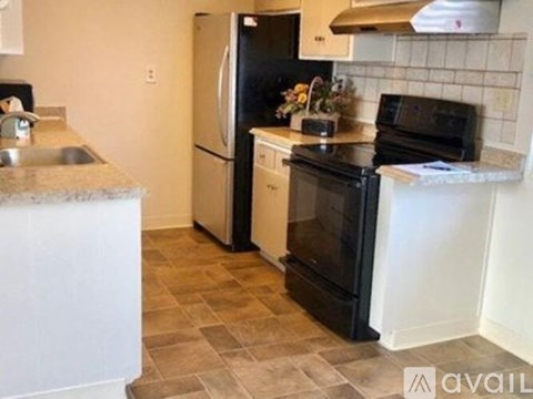 A kitchen with black appliances and a white counter.