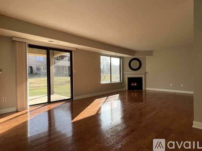A room with wooden floors and a fireplace with a wreath on it.