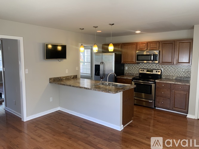A kitchen with a granite countertop and stainless steel appliances.