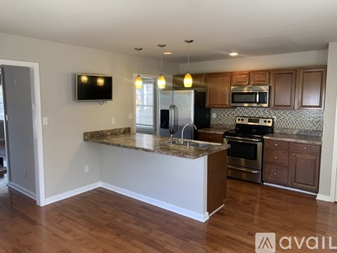 A kitchen with a granite countertop and stainless steel appliances.