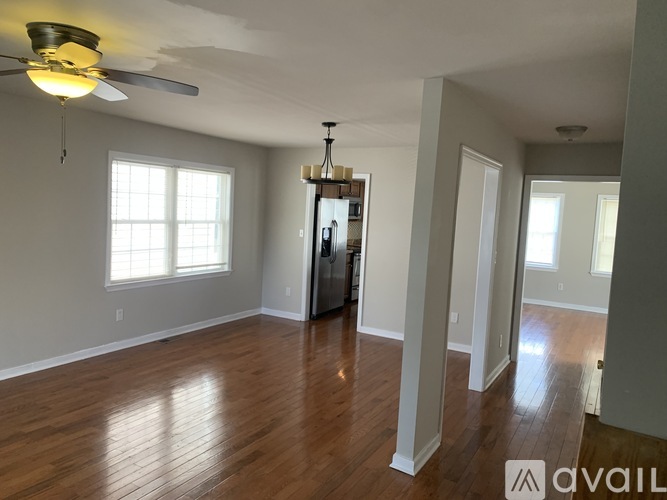 A room with wooden floors and a ceiling fan.