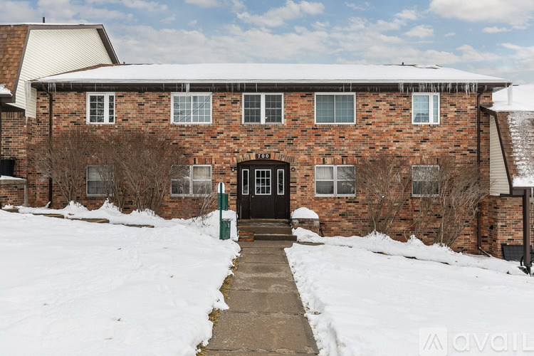 A brick building with a black door and windows, surrounded by snow.