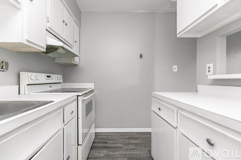 A kitchen with white cabinets and appliances.
