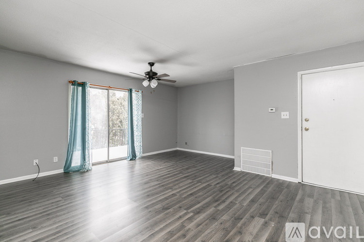 A room with a ceiling fan and wooden flooring.
