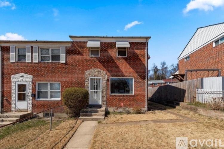 A red brick house with a white door and windows.