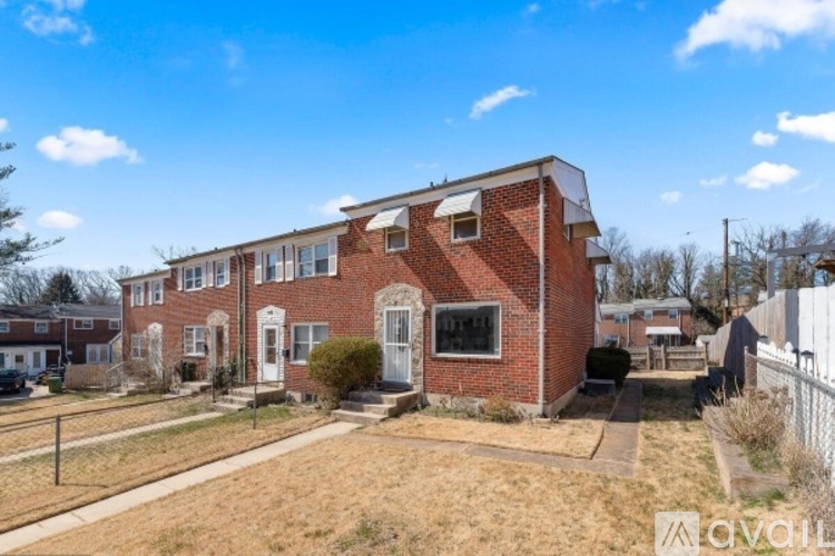 A brick house with a white door and a small front yard.