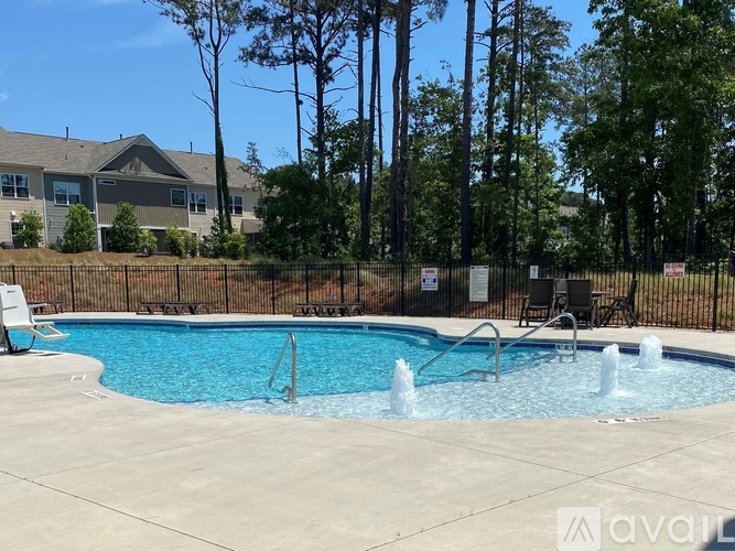 A pool with a fence around it and a building in the background.