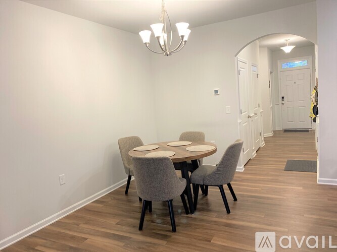 A dining room with a round table and chairs.