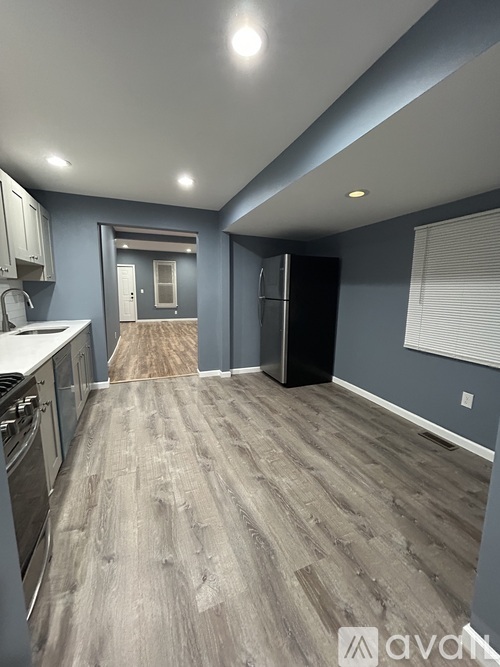 A kitchen with a refrigerator, stove, and cabinets.