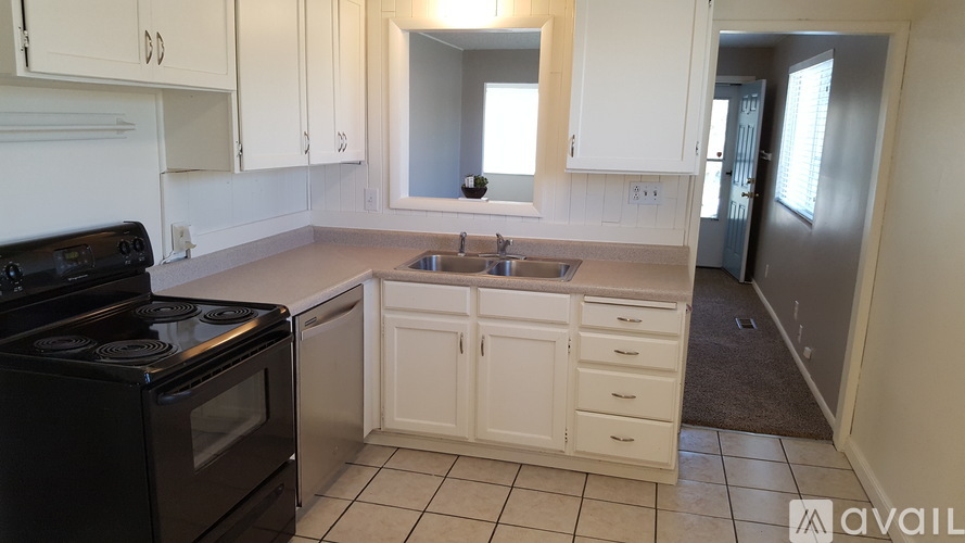 A kitchen with black appliances and white cabinets.