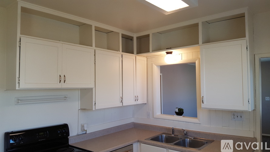 A kitchen with white cabinets and a black oven.