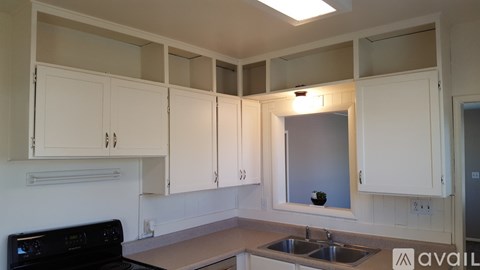 A kitchen with white cabinets and a black oven.