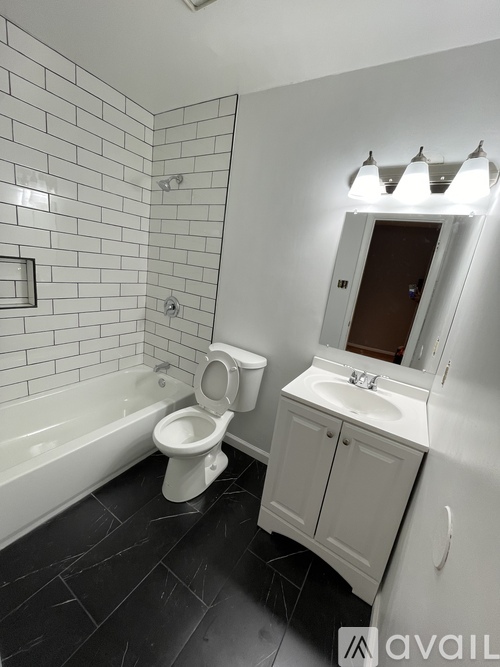 A white bathroom with a toilet, sink, and tub.