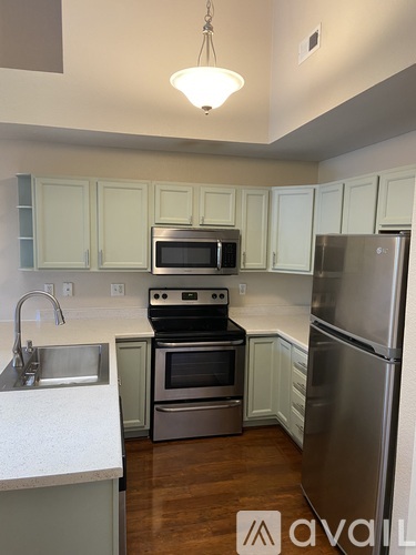 A kitchen with a sink, stove, oven, and refrigerator.