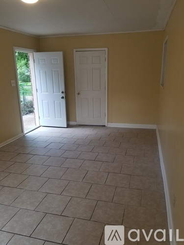 A room with tile flooring and two doors.