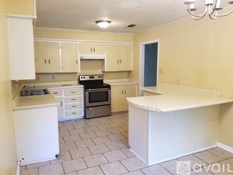 A kitchen with white cabinets and a white island.