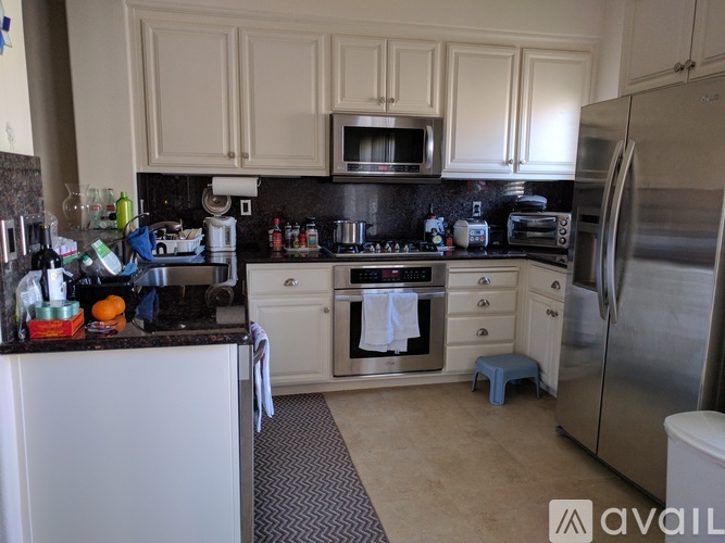 A kitchen with white cabinets and a black countertop.