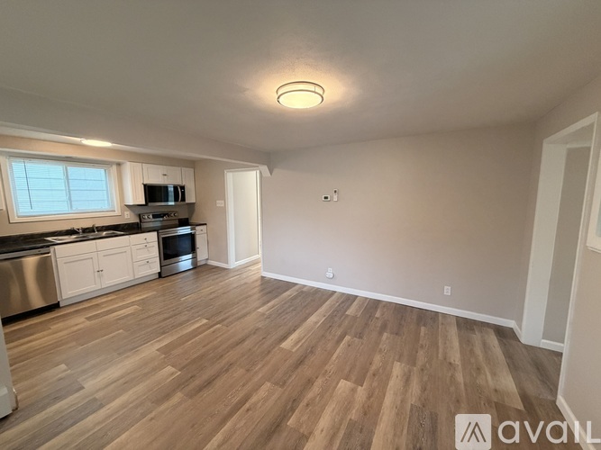 A kitchen with wooden floors and white walls.