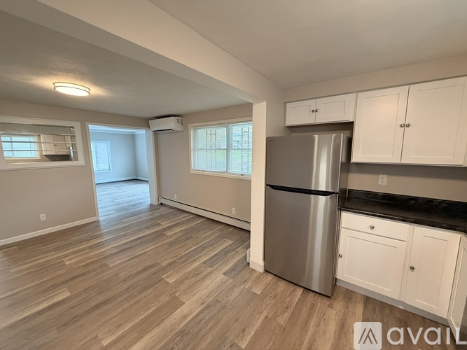 A kitchen with a stainless steel refrigerator and white cabinets.
