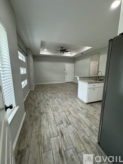 A kitchen with a refrigerator, sink, and cabinets.