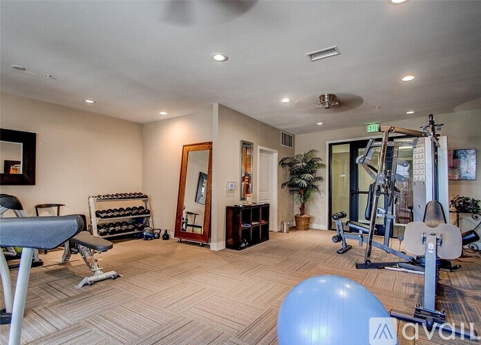 A well-lit home gym with a variety of exercise equipment.