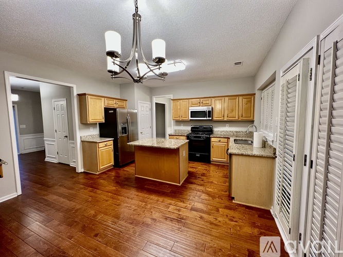 A kitchen with wooden floors and cabinets.