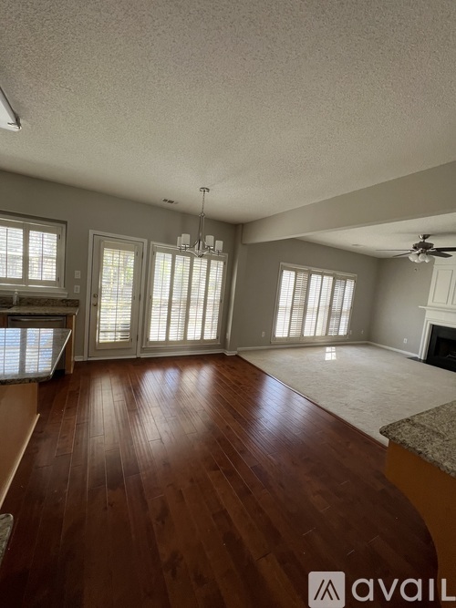 A spacious living room with hardwood floors and a fireplace.