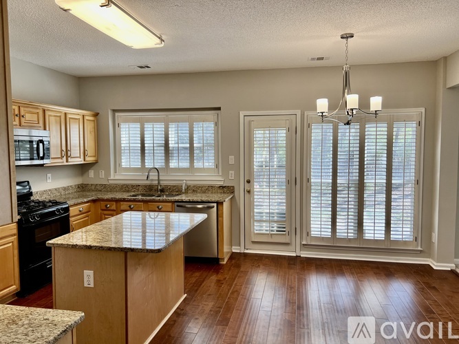 A kitchen with wooden cabinets and a granite countertop.